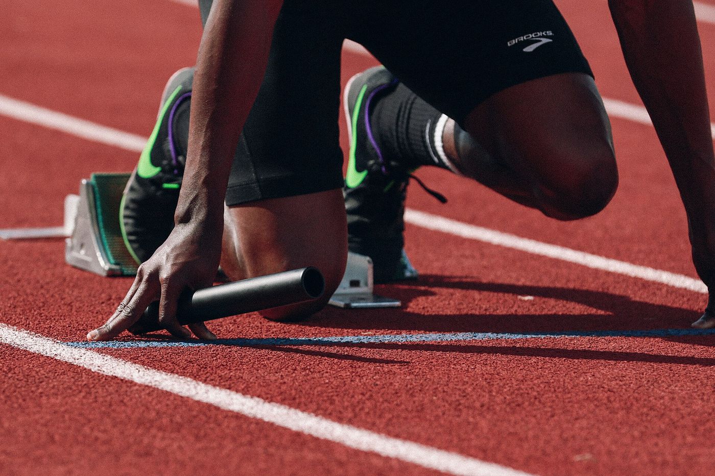 A sprinter's hands set behind the line