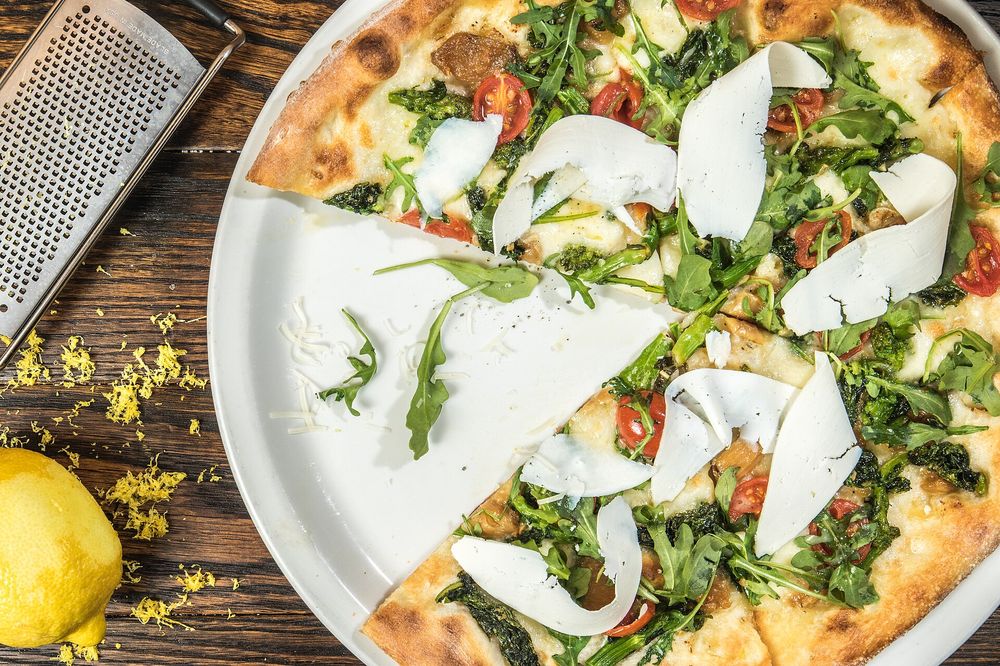 White pizza with greens and shaved cheese