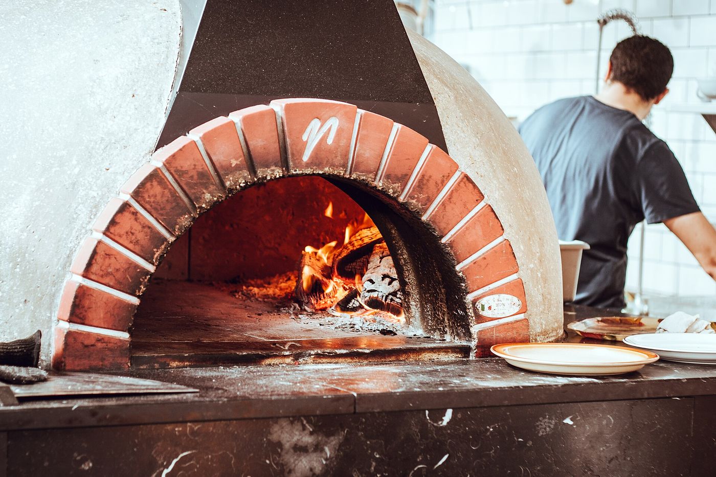 Our pizzaiolo working at the wood-fired oven