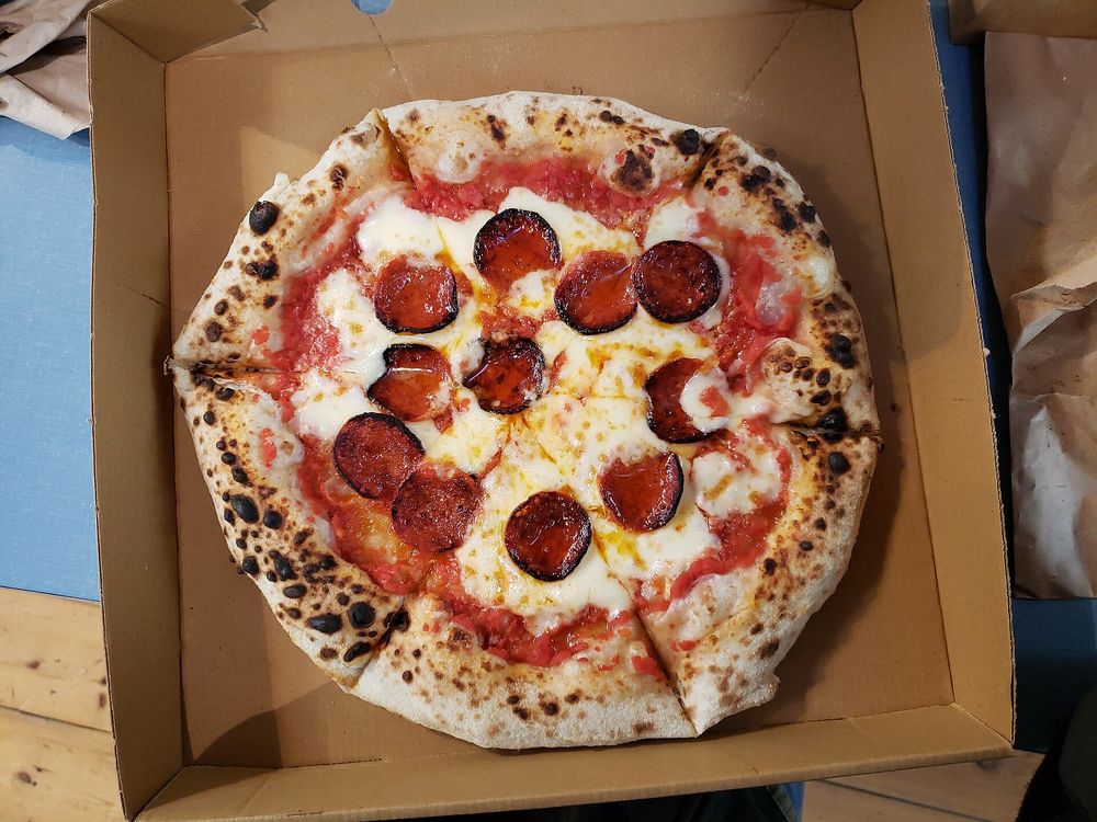 A boxed pepperoni pizza ready for pickup